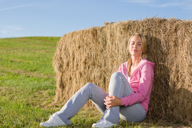 Sportive young woman relax by bales sunset